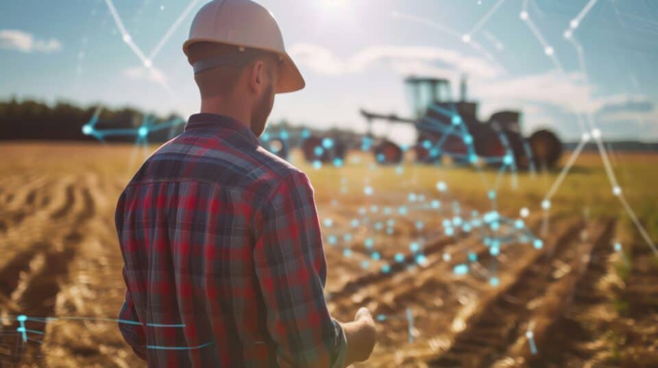 A futuristic image of a farmer monitoring a tractor in a field, with glowing digital farming network overlaid